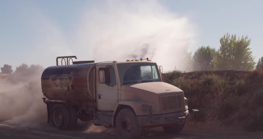 A truck drives on a dirt road