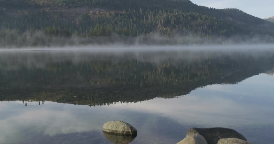 Steam hovers over a rippling mountain lake