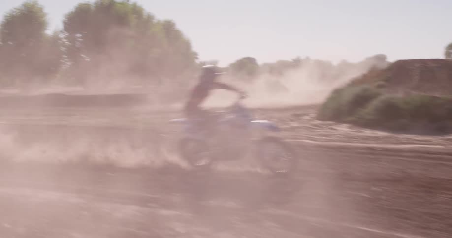 A dirt biker does a huge jump over a hill