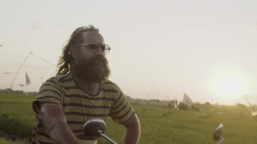 A man is riding a motorcycle on a cloudy day