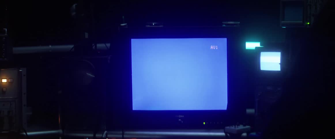 A man working on setting up and audio visual display with lots of equipment and wires