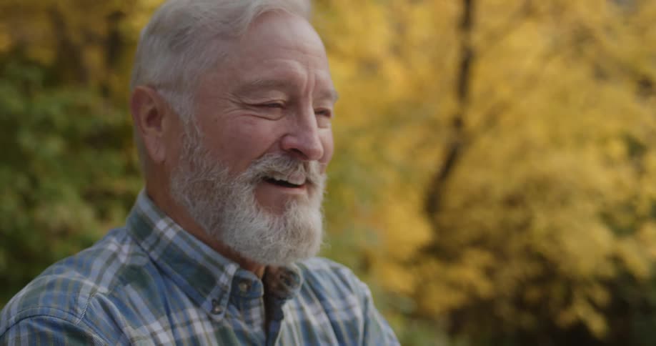 A man standing outdoors laughing