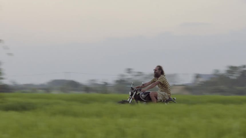 A motorcyclist rides in a rural area