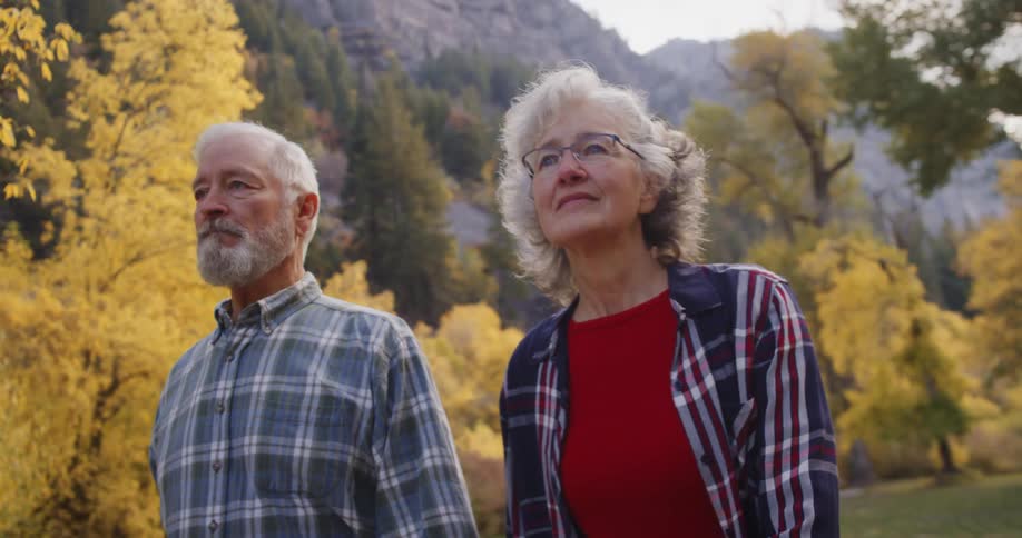 A man and woman are hiking past the trees