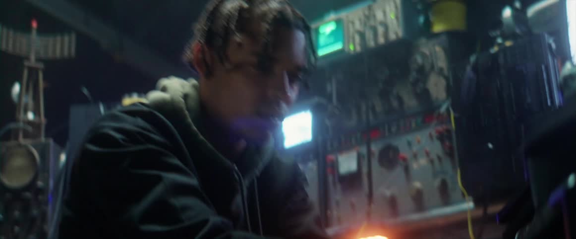 Young man using electronic equipment under strobing lights inside a dimly lit room
