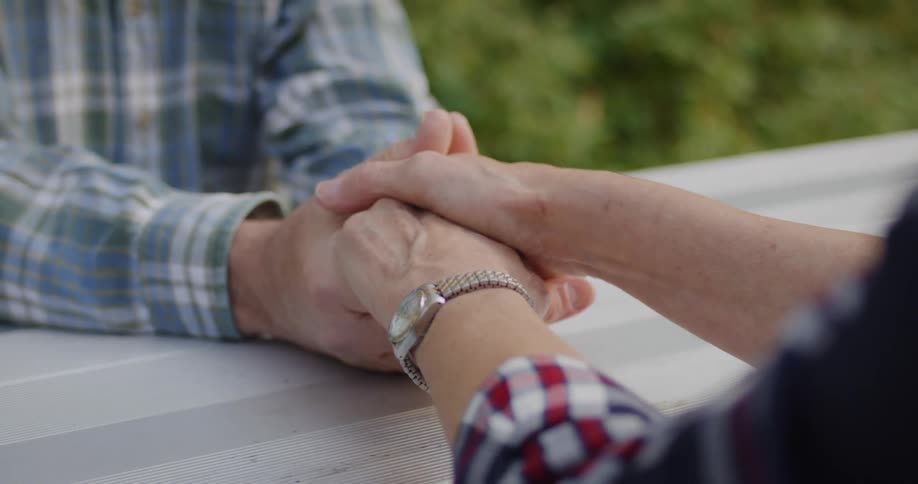Couple holding hands over a table outdoors