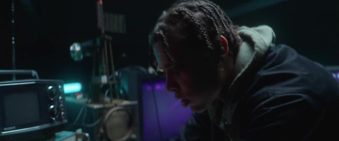 Young man using electronic equipment inside a dimly lit room