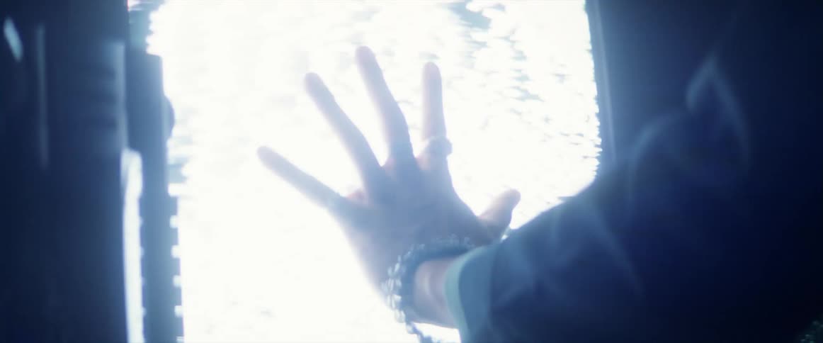 A person puts their hand on the television screen