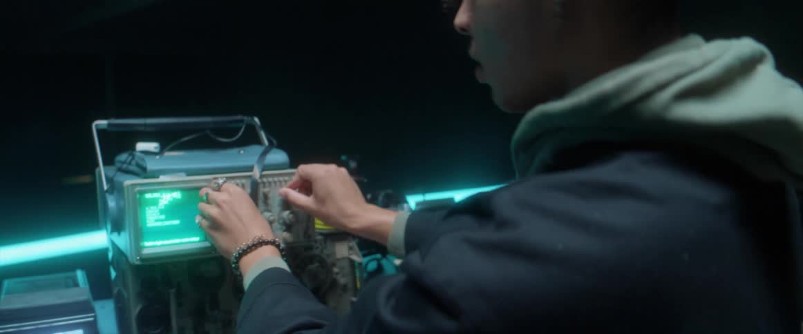 Young man using electronic equipment inside a dimly lit room