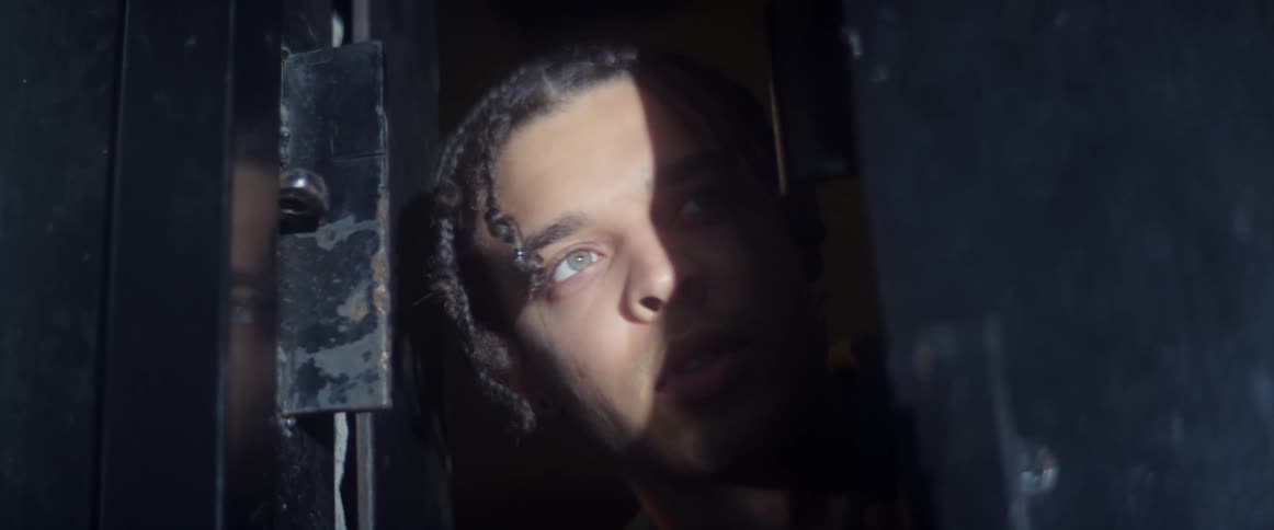 A man looks scared as he sticks his head out a window