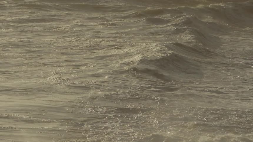 Waves crash around at sunset