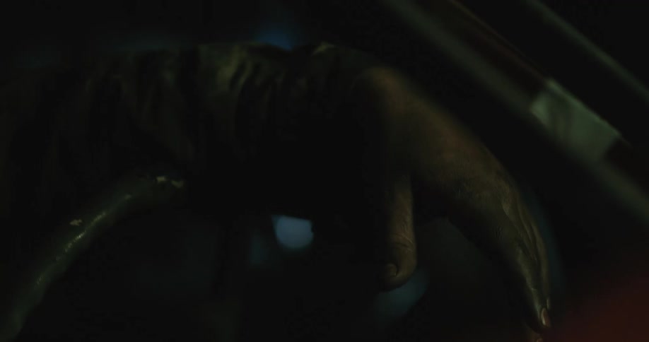 A dirty hand hangs from the steering wheel