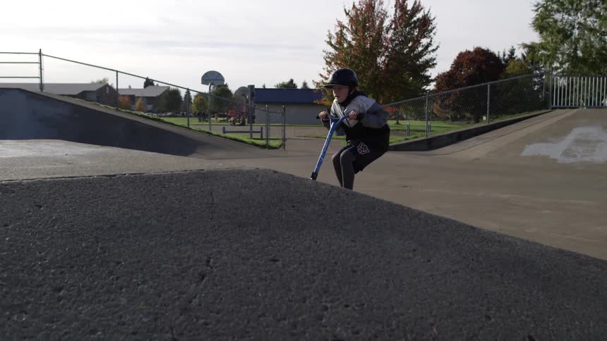 A kid is does a jump in a skate park