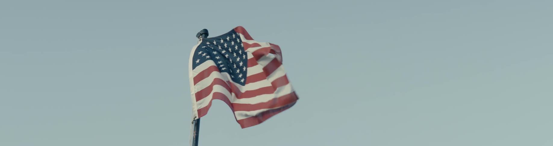 An american flag blows in strong wind outdoors