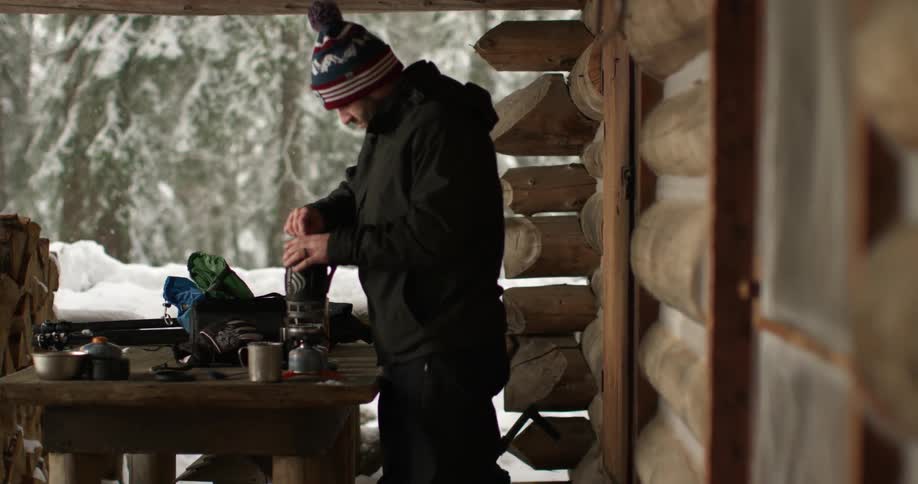 A man stirs something in a cap