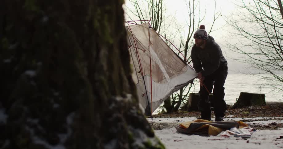 A man is setting up a tent