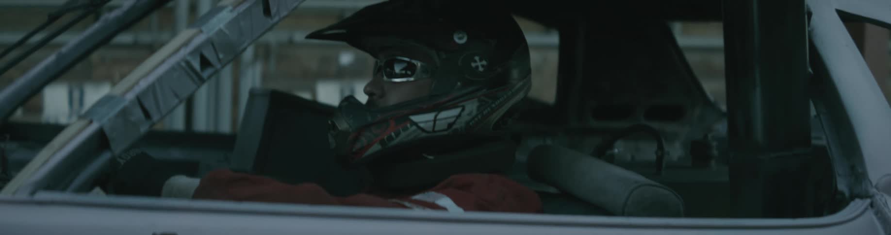 A race car driver sits in his car