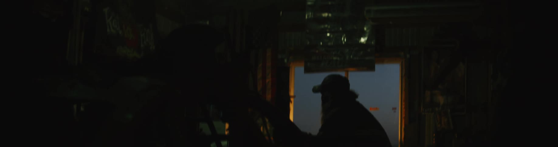 A man is standing in a garage during the night time