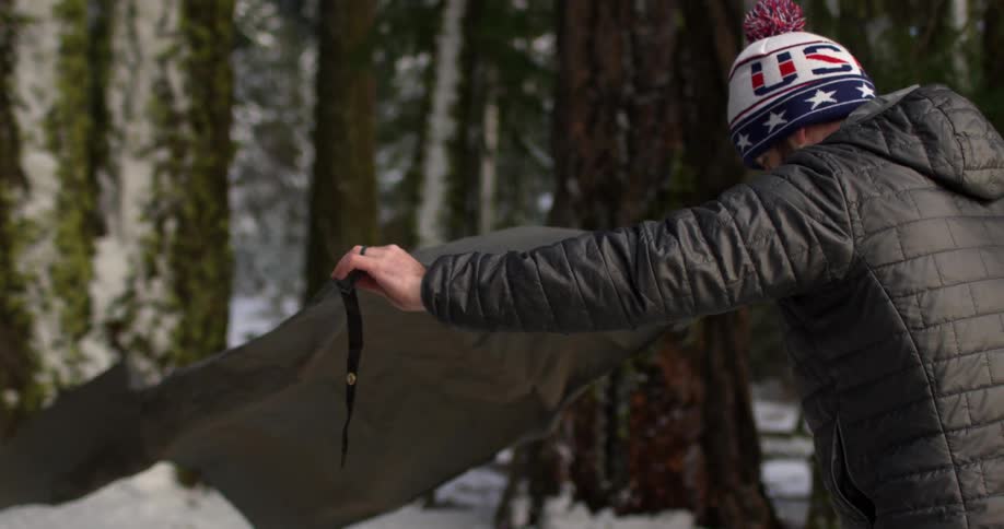A man lays down a sheet on snow