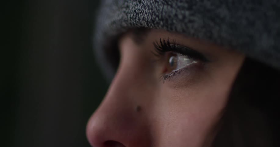 A brown eyed woman looks around