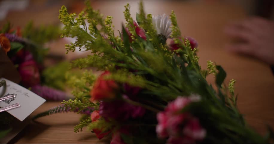 A florist sets a bouquet of flowers on a table
