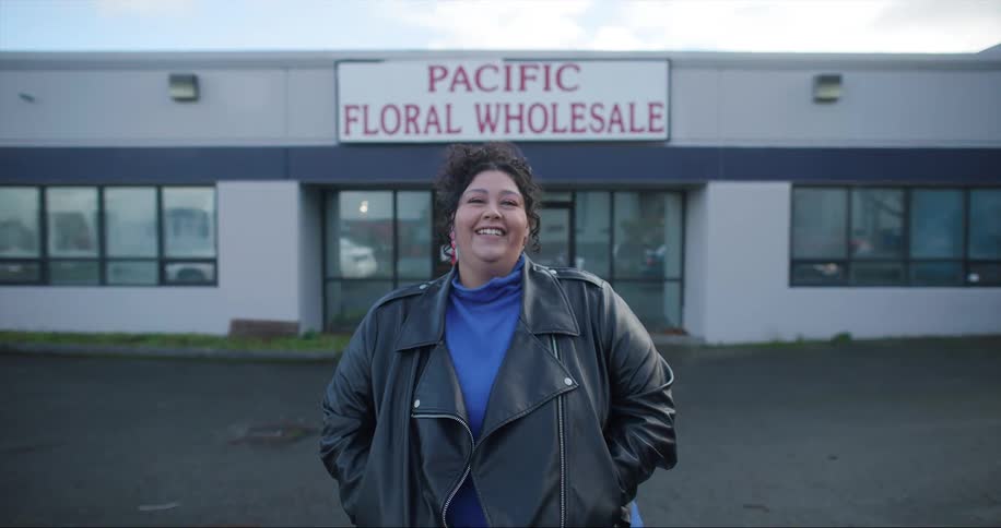 Woman laughs while posing in front of wholesale store