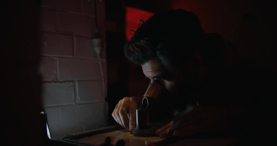 A man looking through a microscope lens