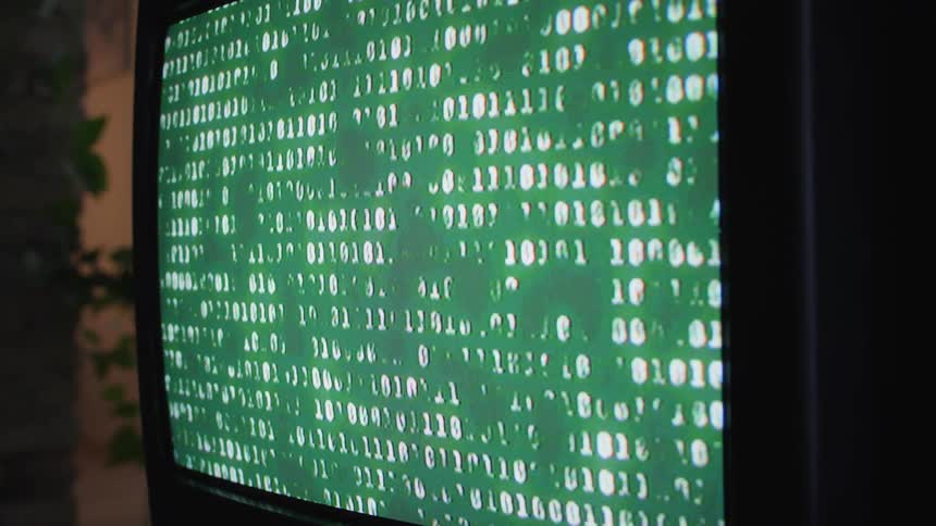 A television screen is showing the numbers ones and zeros as a shadow moves around from inside