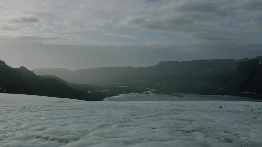 Valley stretches from glacier to misty mountains on the horizon