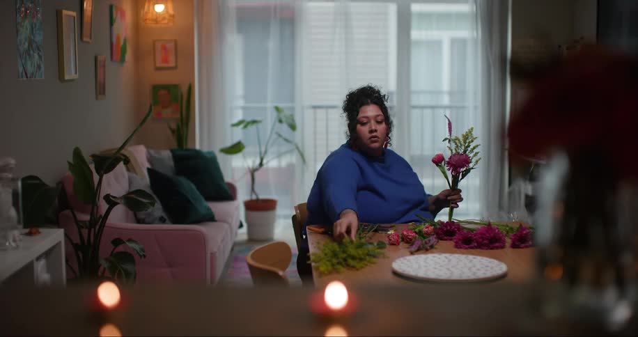 A woman is gathering flowers into a bouquet