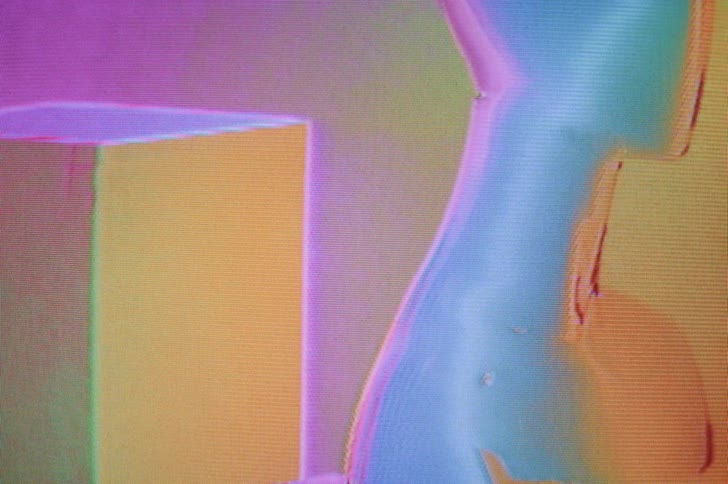 An image of a cube and a humanoid like figure is bathed in pulsing rainbow colors