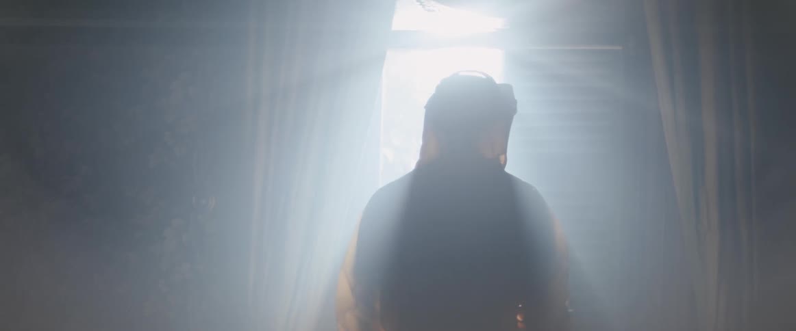 A man in a hazmat suit walks over to the window