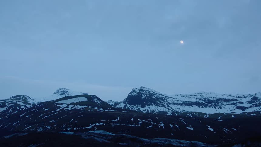 Distant view of snowy mountain range at dusk