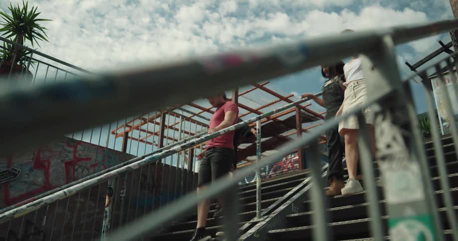 A group of friends walk down graffitied steps downtown