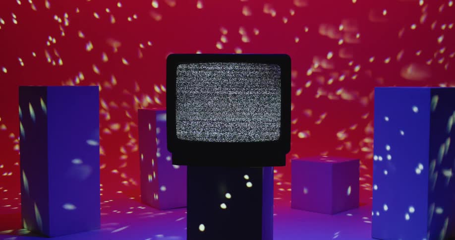 Vintage tv with static screen on pillar against red wall with white lights