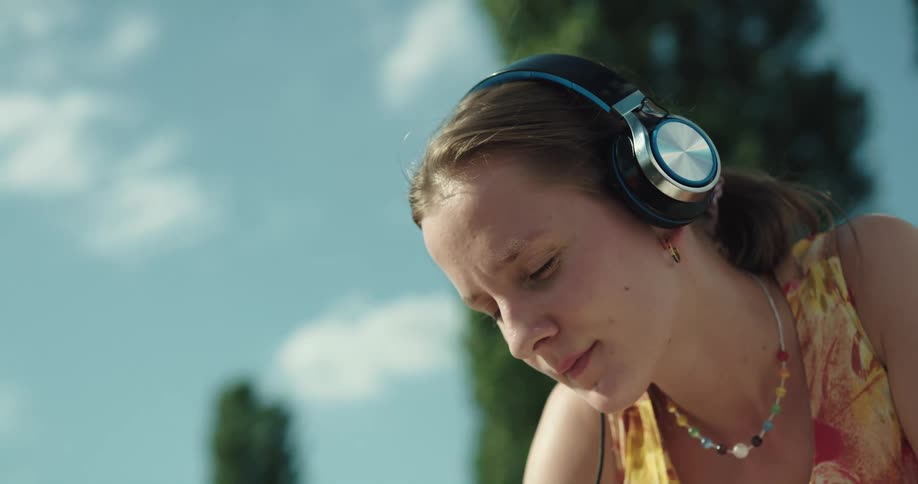 A teenage girl outside with headphones on