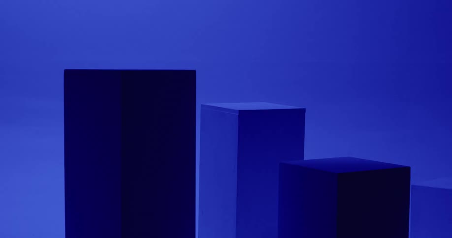 Rectangle shaped boxes are sitting on the floor of an empty room as flashing lights shine on the boxes and floor as well as the walls