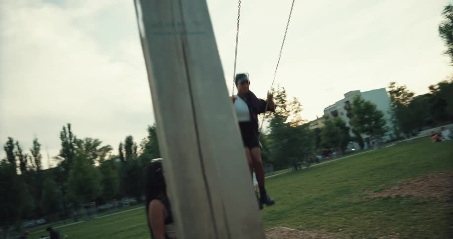 A woman is swinging in the park