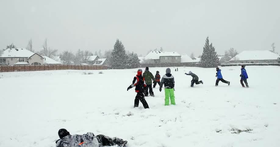 A group of kids playing football in the snow
