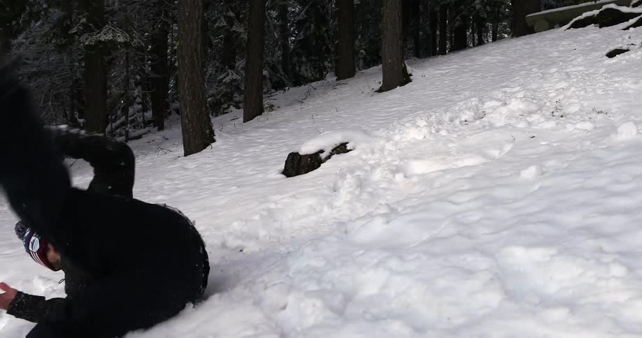 A man dodging snowballs tumbles downhill