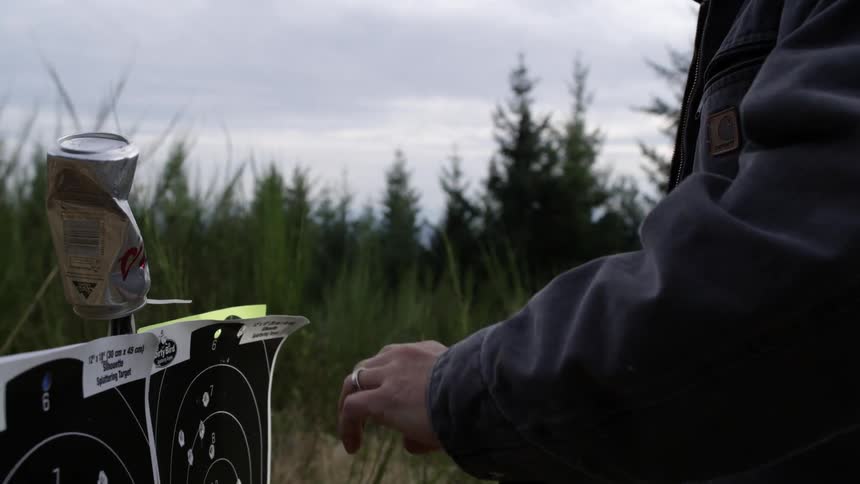 A man collects a knife from a target