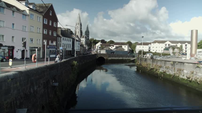 A person walks over to the edge of a canal in the distance
