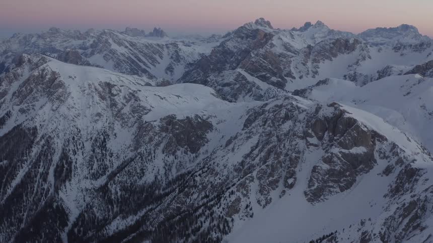 A blanket of snow covers the top of a mountain range