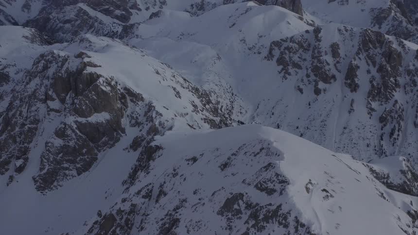 A snowy mountain range on a cloudy evening
