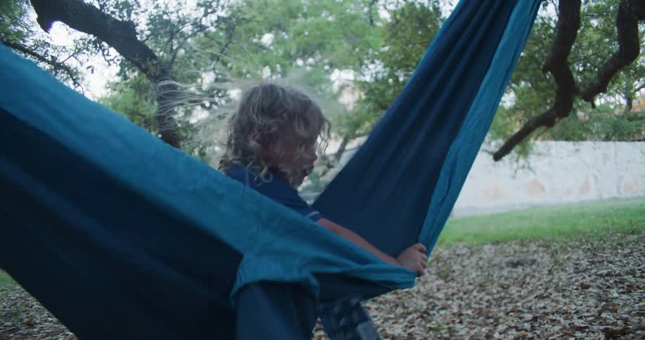 A child is playing in a hammock