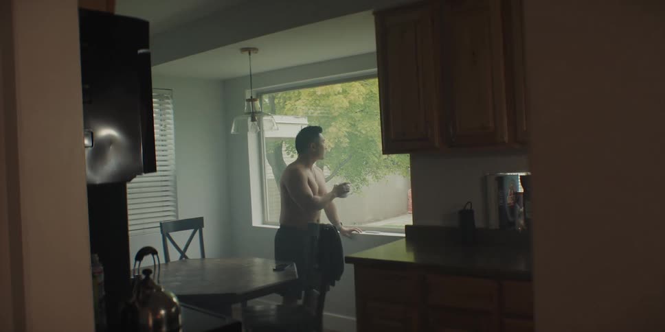 A man standing in a room drinking