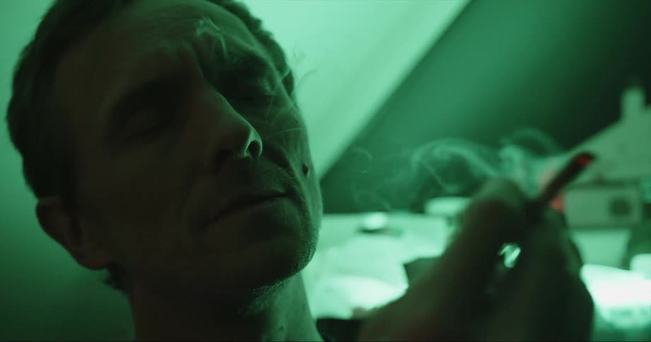 A man inhales deeply with his head back and looks relieved and relaxed when he exhales