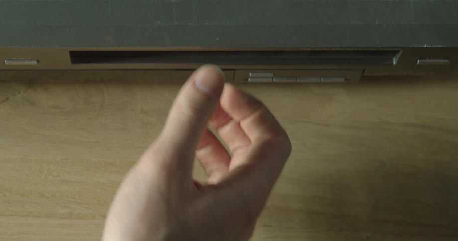 A person inserts a video cassette in the vcr