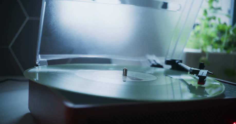 The sun shines on a vinyl record album as it spins on a turntable