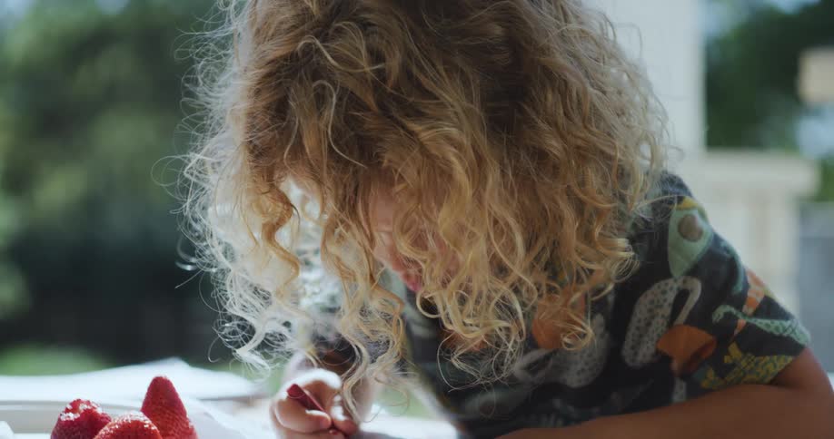 A child is coloring with a crayon